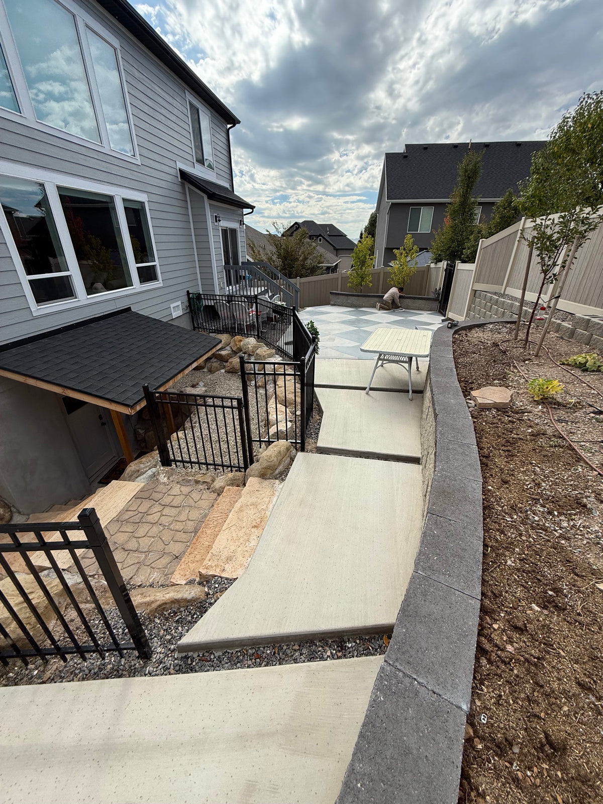 Concrete walkway and steps beside a block retaining wall in Lehi, UT