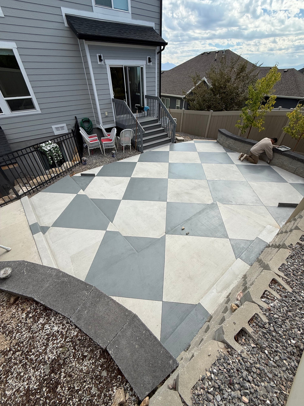 Two-tone checkerboard stained concrete patio in a Lehi, UT backyard